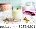 Garlic sauce in a glass with garlic gloves 32534801
