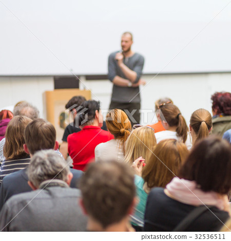 Man giving presentation in lecture hall at 32536511