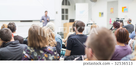 Man giving presentation in lecture hall at 32536513