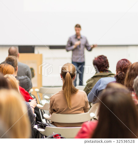 Man giving presentation in lecture hall at 32536528
