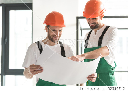 Beaming male constructors discussing project Beaming male constructors discussing project 32536742