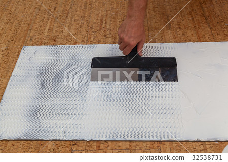imposition of glue a spatula on an isolating panel 32538731