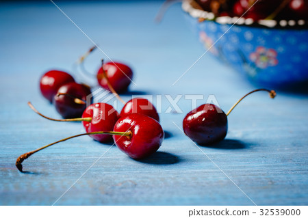 Cherries scattered on a wooden countertop Cherries scattered on a wooden countertop 32539000