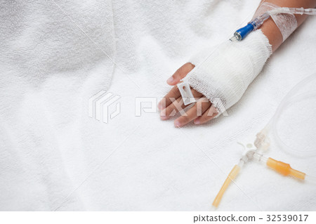Child's hand with saline intravenous (iv) drip 32539017