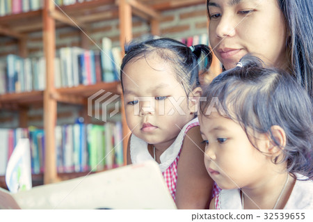 Mother and little daughter reading book together 32539655
