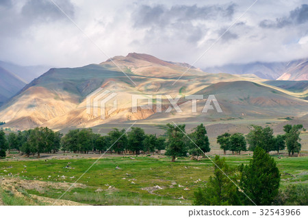 Clouds pass over mountain pinnacle in sunset light 32543966