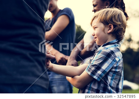 Group of people holding hand together in the park 32547895