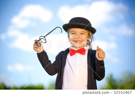 Funny little girl in bow tie and bowler hat. 32552467