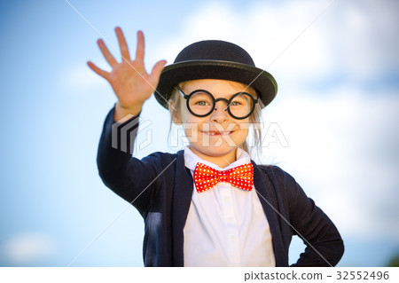 Funny little girl in bow tie and bowler hat with 32552496