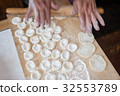 Rolling the dough with a rolling pin. 32553789