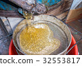 Strain the poured honey through a sieve. Filtering 32553817