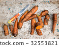 Dirty carrots and knife on an aluminum table 32553821