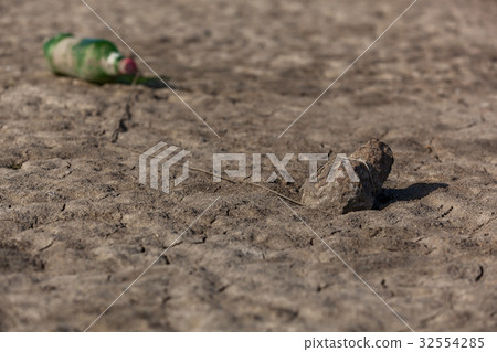 A plastic bottle is tied by a rope to the stone 32554285