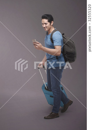 Traveler asian man with backpack using smartphone Traveler asian man with backpack using smartphone 32555320