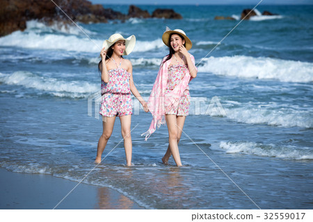 Two women Wearing a hat walking enjoy 32559017