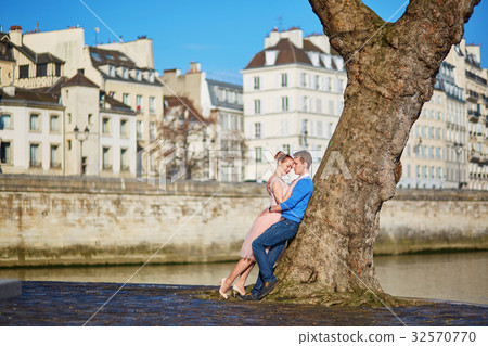 Romantic couple on the Seine embankment in Paris, France Romantic couple on the Seine embankment in Paris, France 32570770