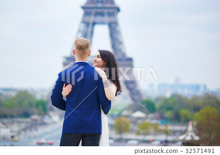 Romantic couple in Paris near the Eiffel tower Romantic couple in Paris near the Eiffel tower 32571491