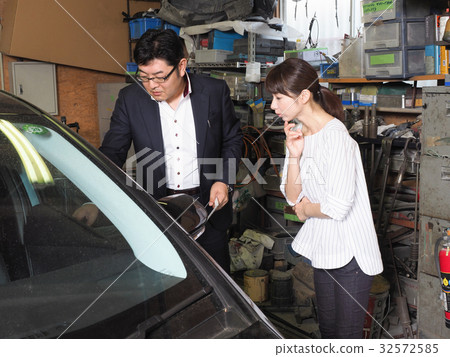 A woman who consults an insurance agent at a repair shop 32572585