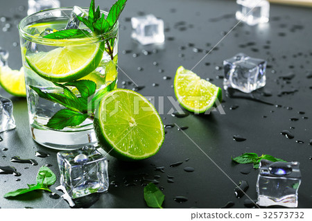 Mojito cocktail with lime, ice cubes and mint Mojito cocktail with lime, ice cubes and mint 32573732