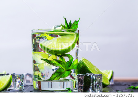 Mojito cocktail with lime, ice cubes and mint Mojito cocktail with lime, ice cubes and mint 32573733