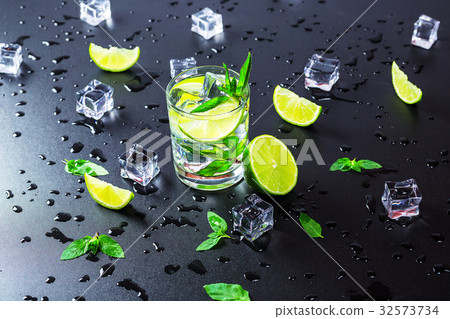 Mojito cocktail with lime, ice cubes and mint Mojito cocktail with lime, ice cubes and mint 32573734