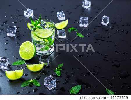 Mojito cocktail with lime, ice cubes and mint Mojito cocktail with lime, ice cubes and mint 32573739