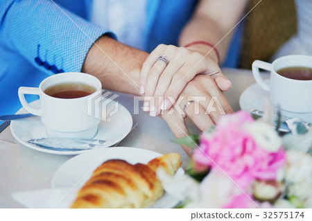 Just married couple holding hands in Parisian cafe Just married couple holding hands in Parisian cafe 32575174