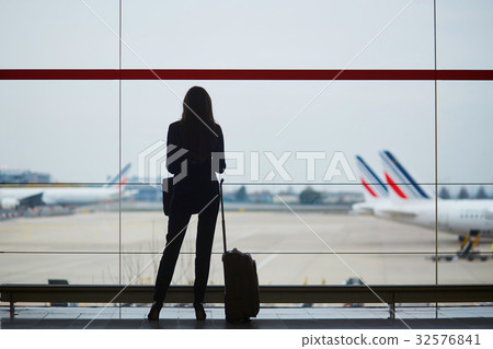 Woman with hand luggage in international airport, looking throug 32576841