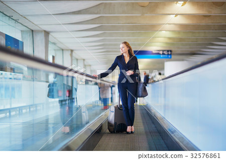Woman on travelator in the international airport Woman on travelator in the international airport 32576861