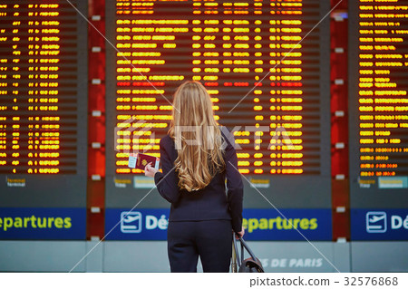 Woman with hand luggage in international airport terminal, looki 32576868