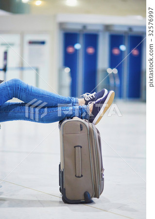 Closeup of woman feet on a suitcase in international airport 32576997