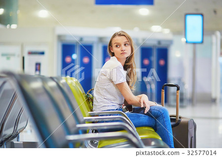 Tourist girl in international airport, waiting for her flight, looking upset 32577014