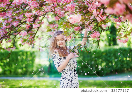 Beautiful young woman in blooming spring park Beautiful young woman in blooming spring park 32577137