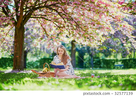 Beautiful young woman in blooming spring park Beautiful young woman in blooming spring park 32577139