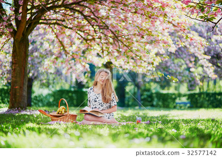 Beautiful young woman in blooming spring park Beautiful young woman in blooming spring park 32577142