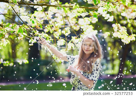 Beautiful young woman in blooming spring park 32577253