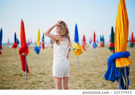 Woman with famous colorful parasols on Deauville Beach in France 32577455