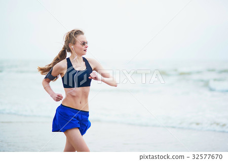Young fitness running woman jogging on beach Young fitness running woman jogging on beach 32577670