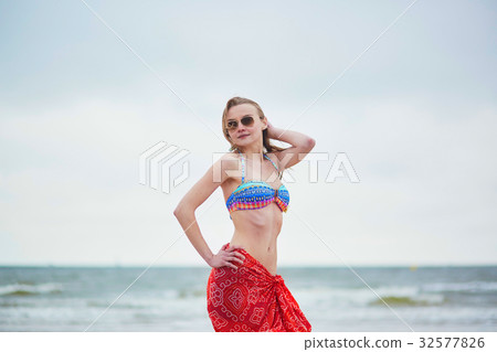 Beautiful young woman in bikini and red pareo 32577826