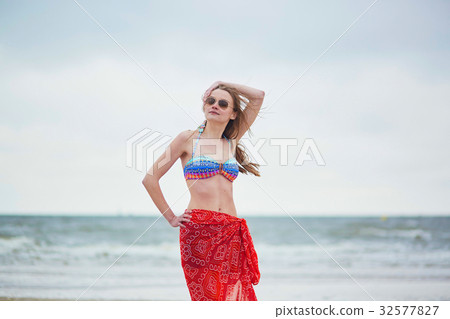 Beautiful young woman in bikini and red pareo 32577827