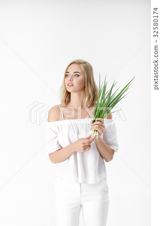 Beautiful blond woman in white blouse holding 32580174