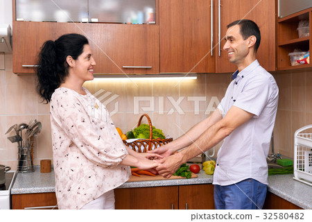 couple in kitchen with fresh fruits and vegetables couple in kitchen with fresh fruits and vegetables 32580482