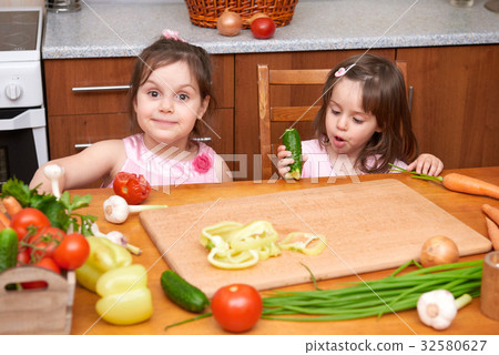 Children with fresh fruits and vegetables at table 32580627