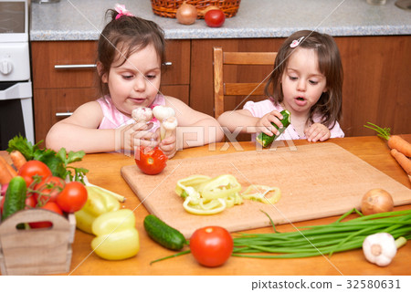 Children with fresh fruits and vegetables at table 32580631