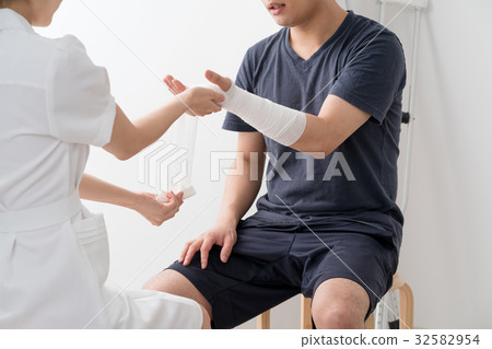 Nurse wrapping a bandage in her arms, patient Nurse wrapping a bandage in her arms, patient 32582954