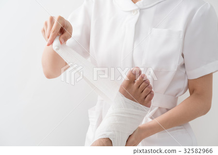 A nurse wrapping a bandage on his feet, a patient A nurse wrapping a bandage on his feet, a patient 32582966