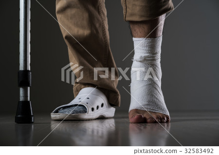 A man injured his leg, a crutch 32583492