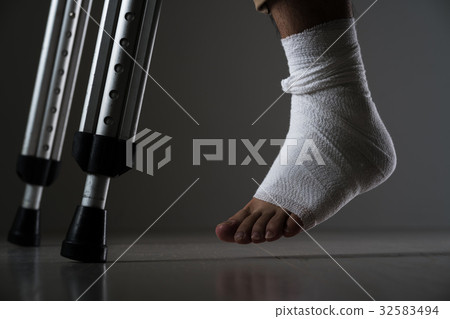 A man injured his leg, a crutch 32583494