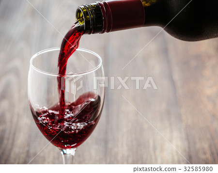 Closeup of red wine pouring in glass 32585980