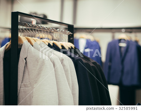 Hangers with different male clothes in store 32585991